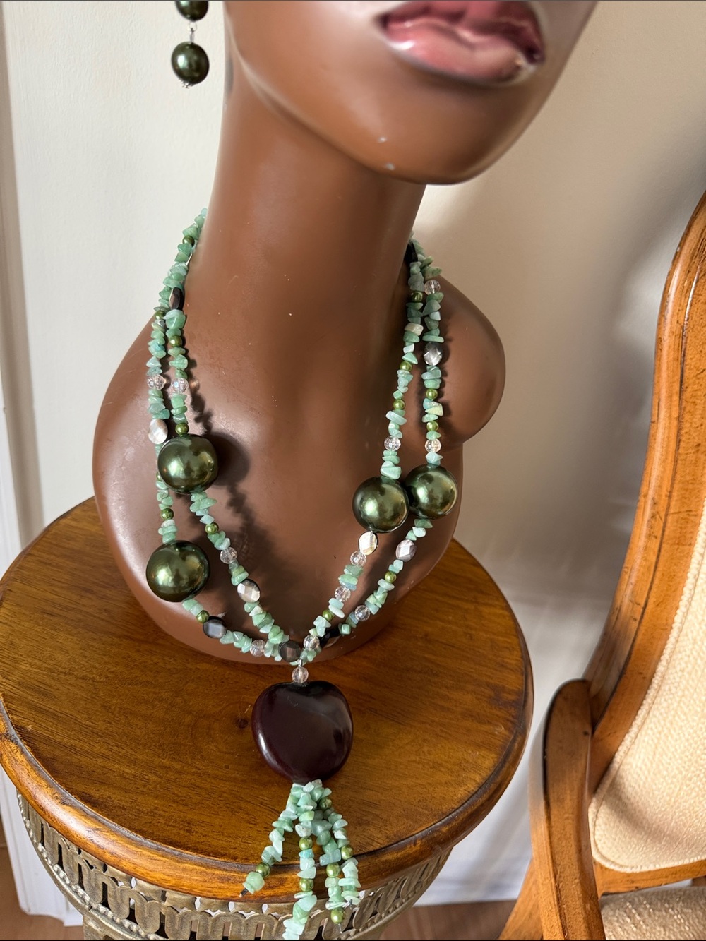 Original one of a kind mahogany seed with green beads and stones and crystals.
